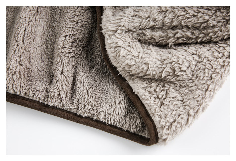 Close-up of the plush gray lining and dark brown bound edge of a garment.