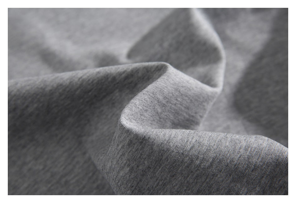 Close-up of heather gray knit fabric draped in folds, highlighting its surface texture.