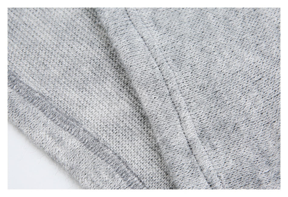 Close-up of gray knit fabric showing a stitched seam and the garment's textured weave.