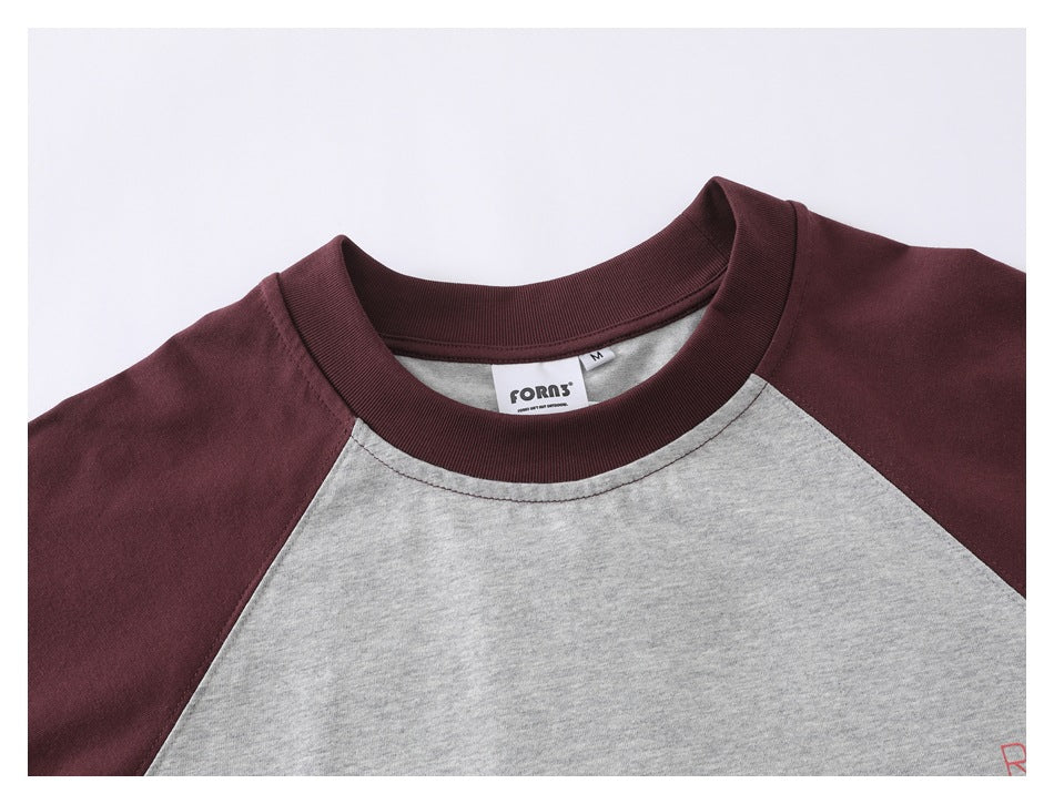 Close-up of the burgundy ribbed collar and gray raglan neckline, with a sewn neck label and M size tag.