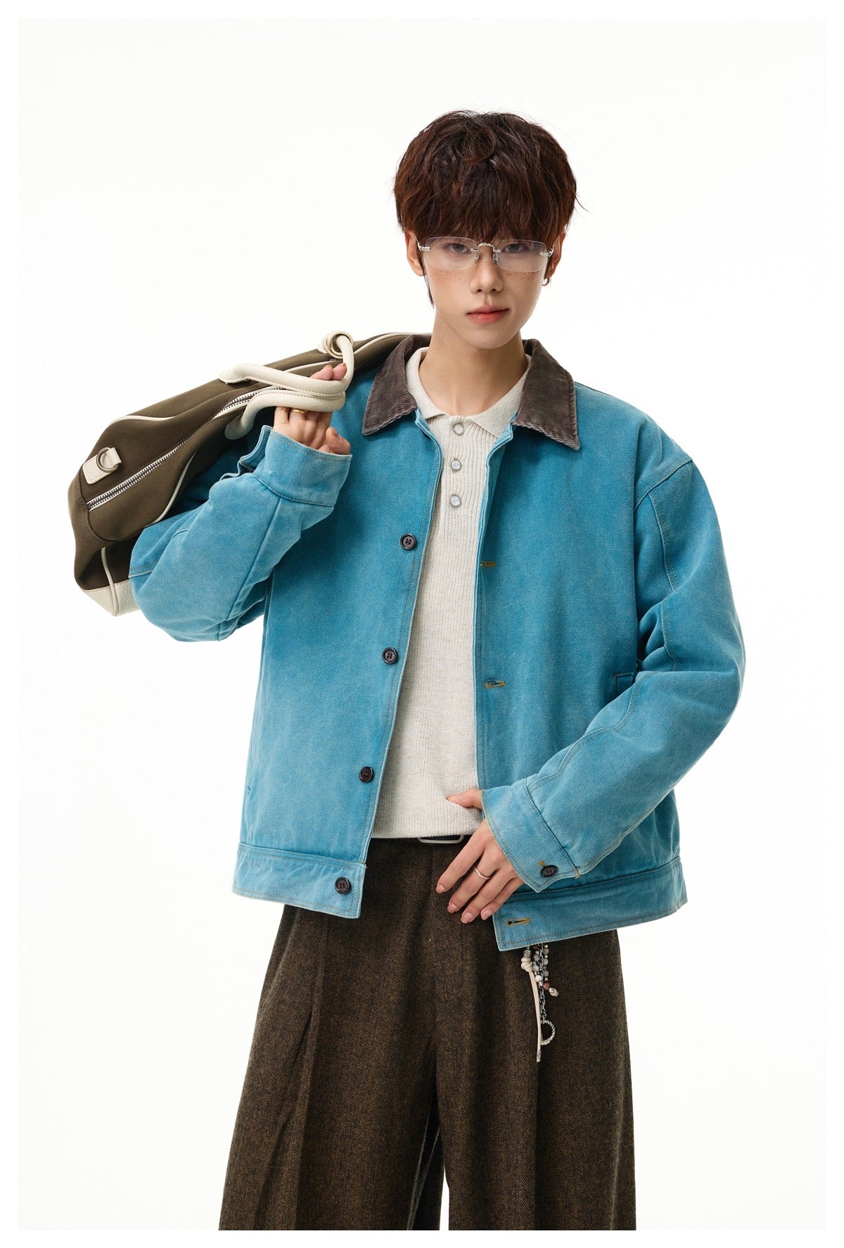 Close-up of a model wearing the teal-blue washed jacket with brown corduroy-look collar over a cream knit polo