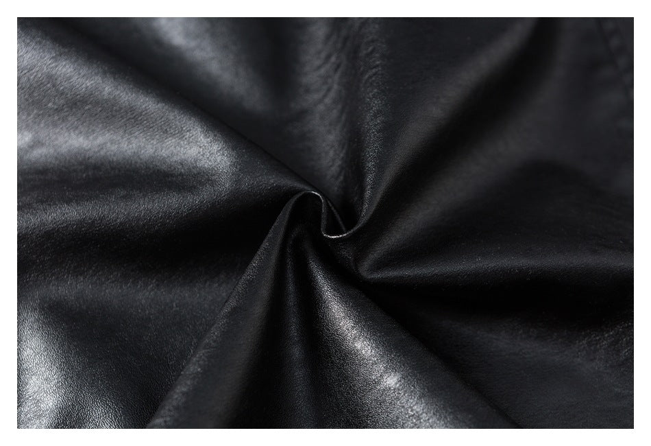 Close-up of glossy black material gathered into folds, showing its smooth surface and sheen.