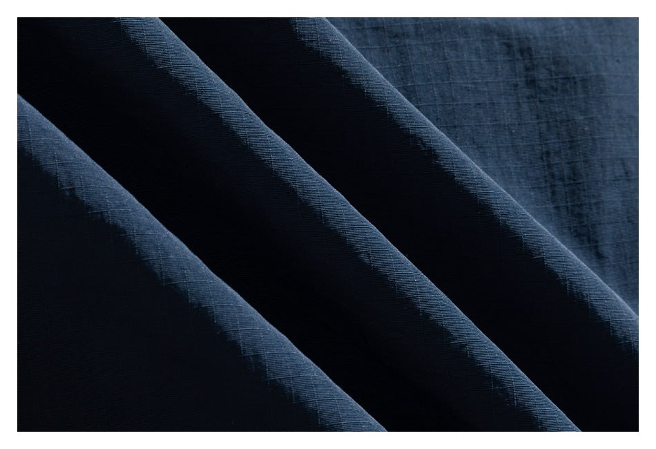 Close-up showing the fine grid texture of dark navy fabric in soft folds.