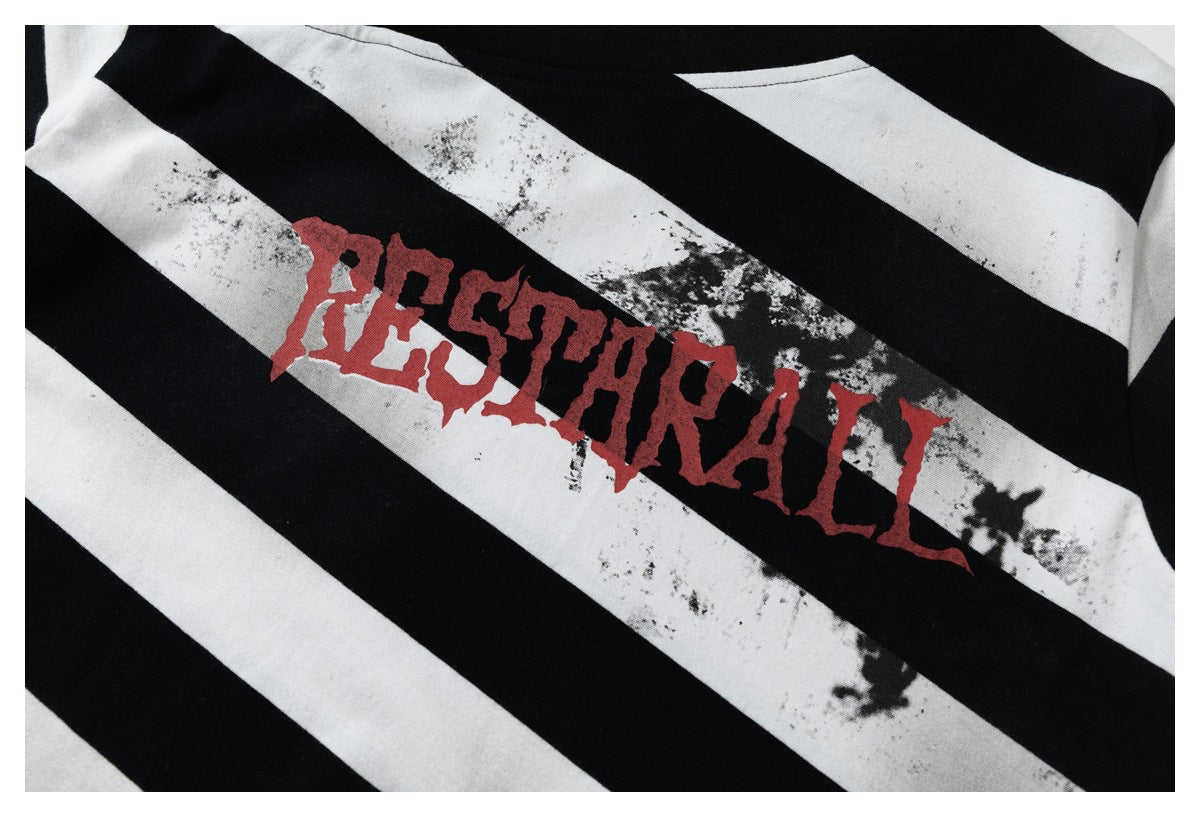 Close-up of distressed black-and-white stripes with large red lettering printed across the garment.