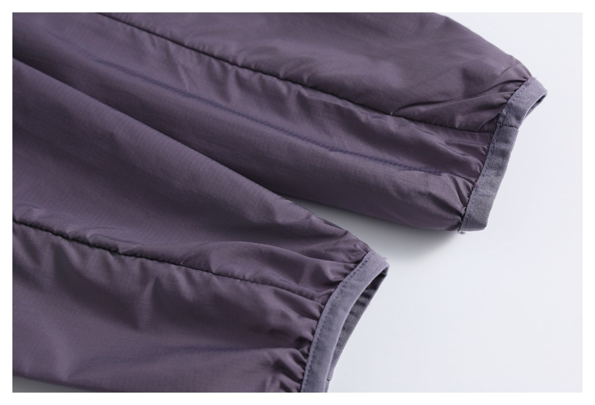 Close-up of the gathered, cuffed sleeve ends on a dark purple jacket.