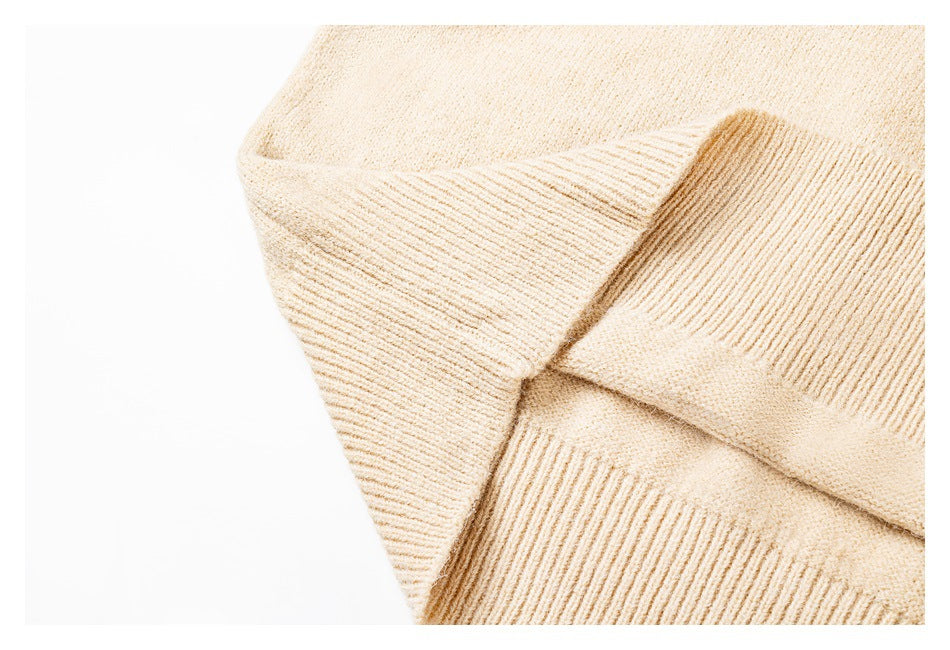 Close-up of the cream sweater’s ribbed hem and knit texture.