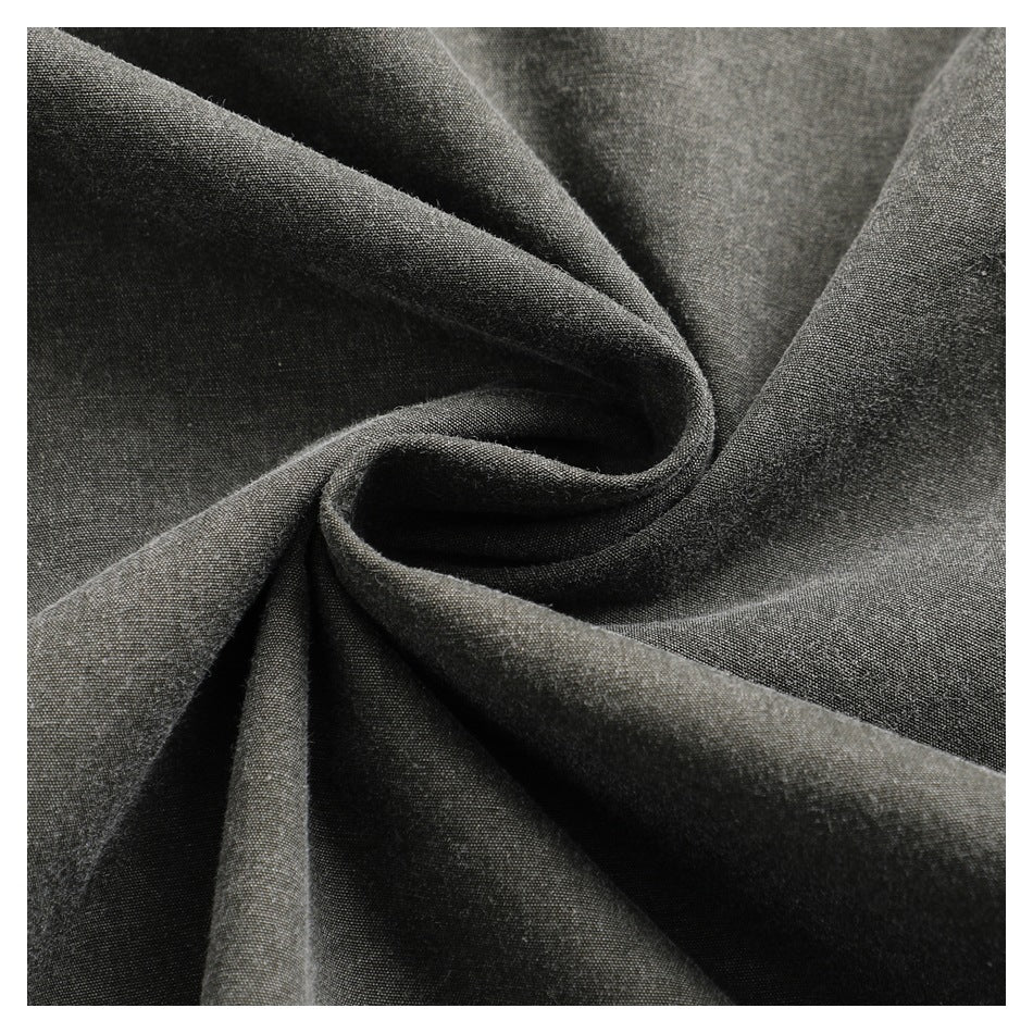 Close-up of charcoal-gray fabric draped into soft folds, showing its fine surface texture.