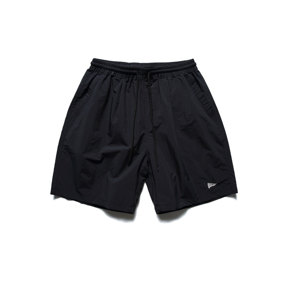 Black drawstring shorts with elastic waist and side pockets, flat lay front view