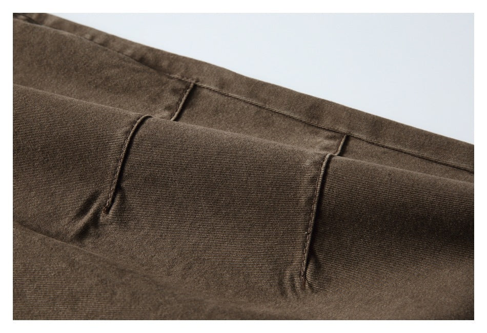 Close-up of the brown trousers' waistband and belt loops, showing the fabric texture and stitching.