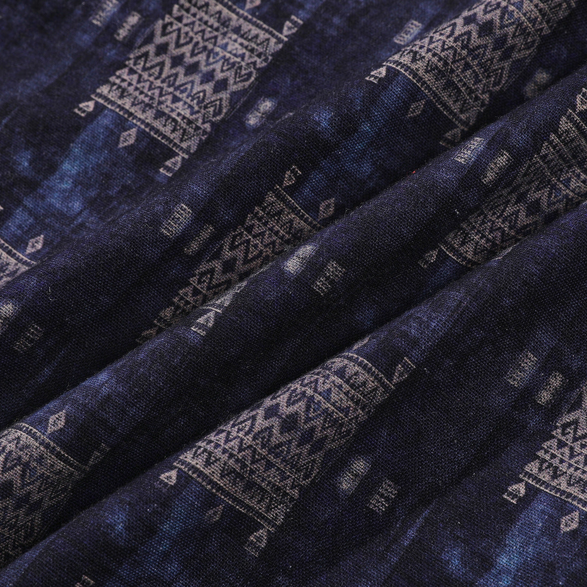 Close-up of draped dark navy fabric with muted geometric patterns.
