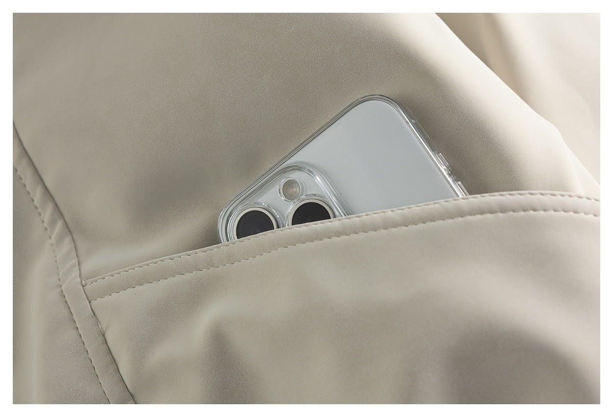 Close-up of an ivory jacket pocket with a smartphone partly tucked inside.