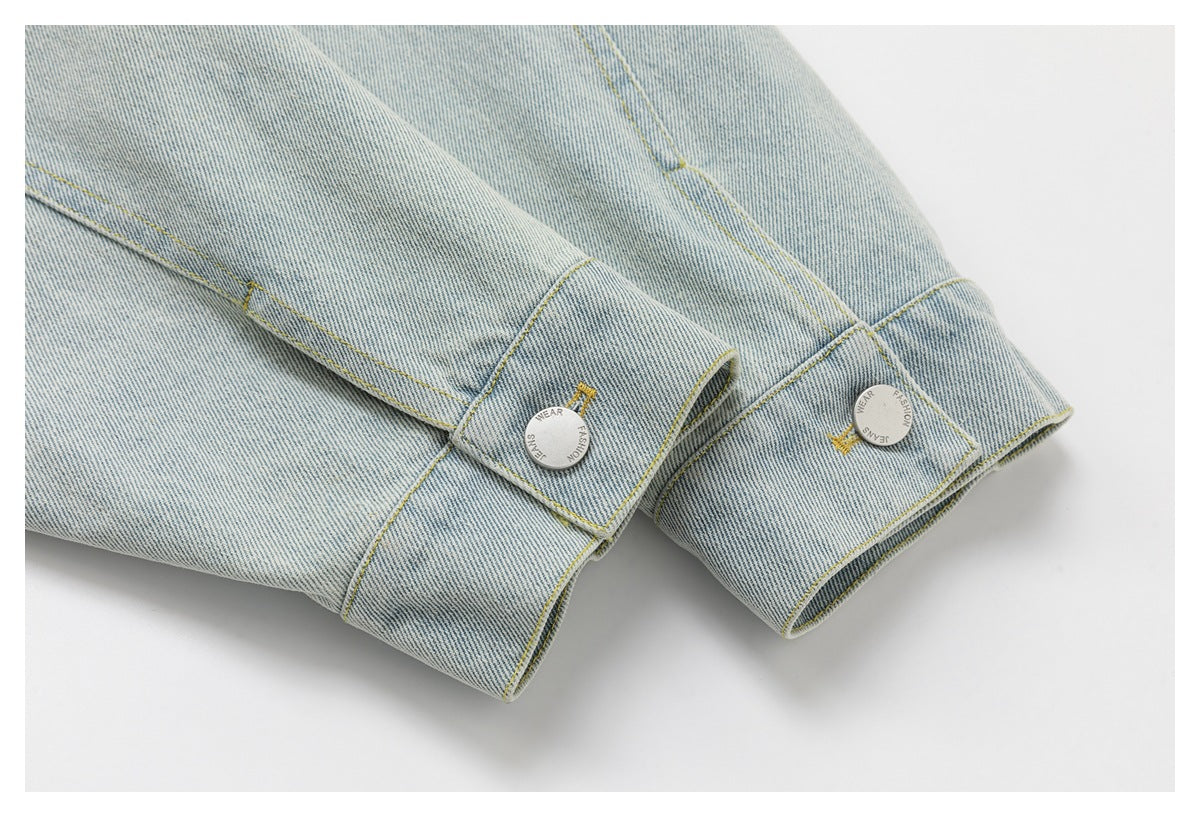 Close-up of pale blue denim jacket cuffs with adjustable button tabs and silver-tone buttons.