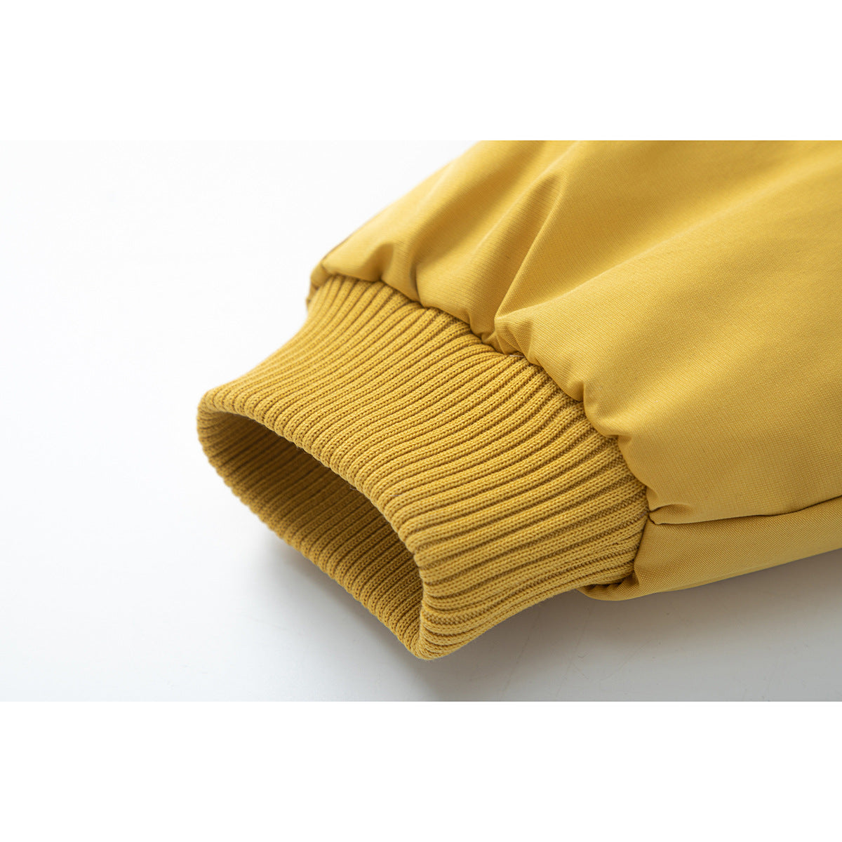 Close-up of the mustard-yellow jacket sleeve and wide ribbed knit cuff.