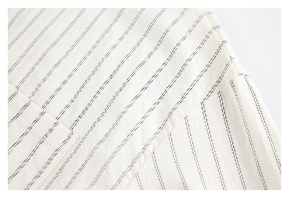 Close-up of striped ivory shirt fabric and a curved side seam.
