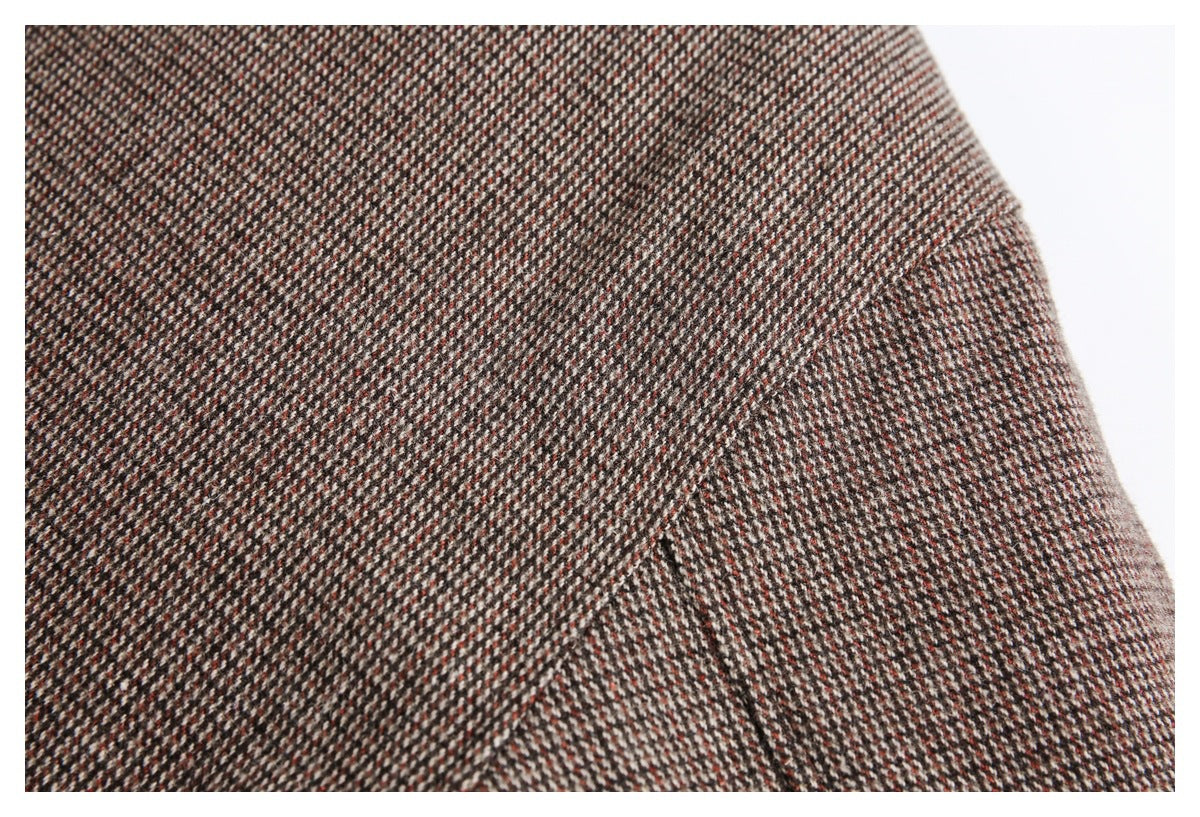 Close-up of brown, cream, and rust tweed fabric showing a seam and curved edge.