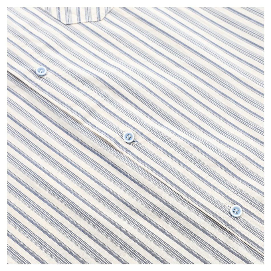 Angled close-up of pale blue buttons and the placket on a cream shirt with blue-gray stripes.