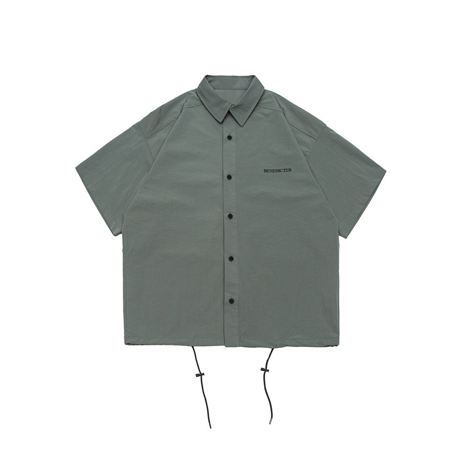 Gray-green short-sleeve button-front shirt with collar, small chest lettering and drawstring hem, flat lay