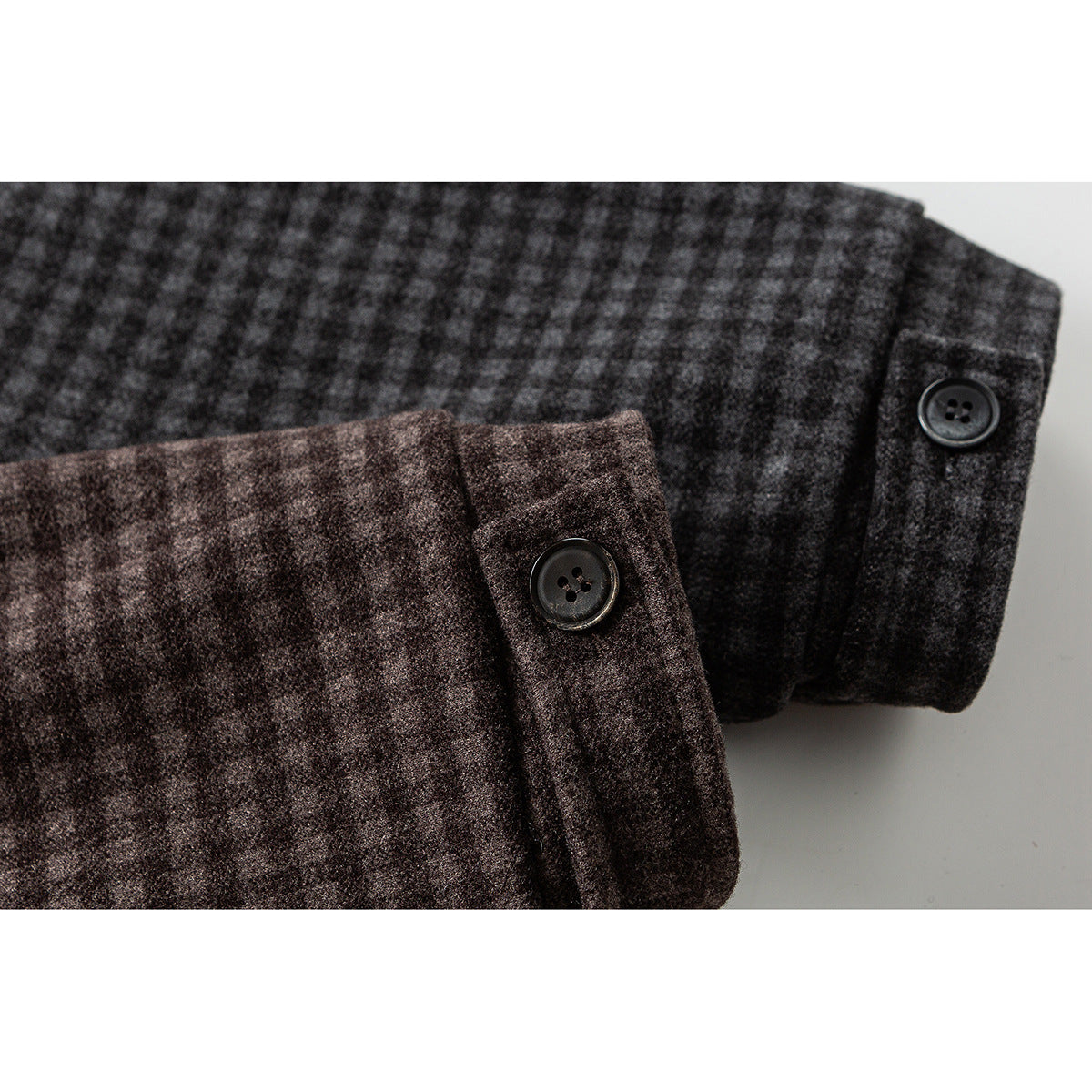 Close-up of buttoned cuffs on brown and charcoal check jacket sleeves.