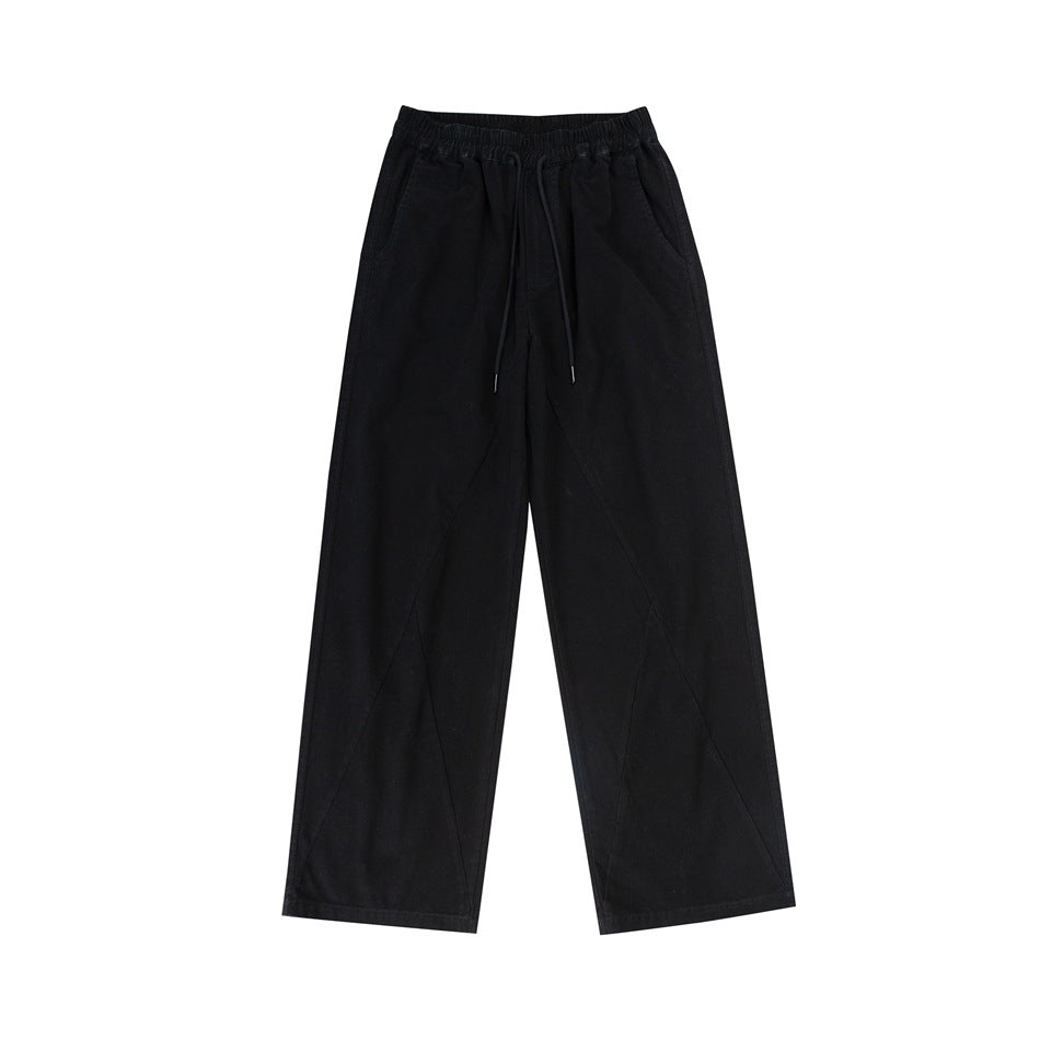 Black wide-leg drawstring pants with elastic waist and diagonal leg seams, flat lay front view