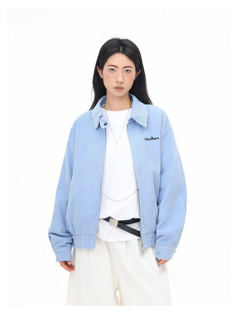 Model wearing an open light blue corduroy jacket over a white tee with white wide-leg pants, front view