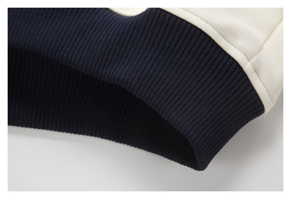 Close-up of a ribbed navy band joined to ivory fabric on a garment.