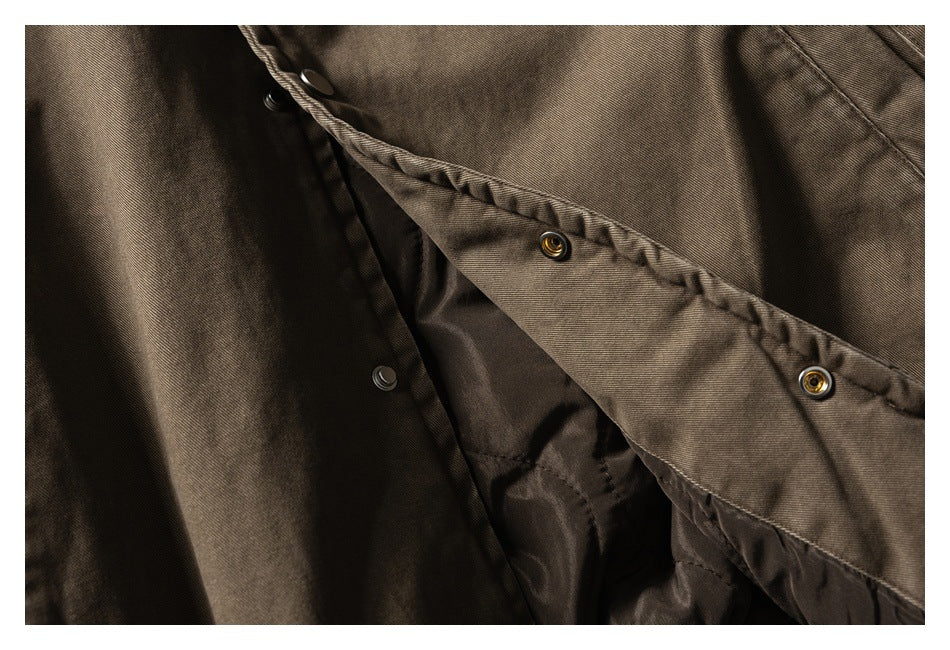 Close-up of the brown jacket’s snap-fastened front placket and dark lining.