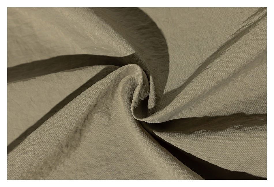 Close-up of khaki fabric gathered into a twist, showing its texture and folds.