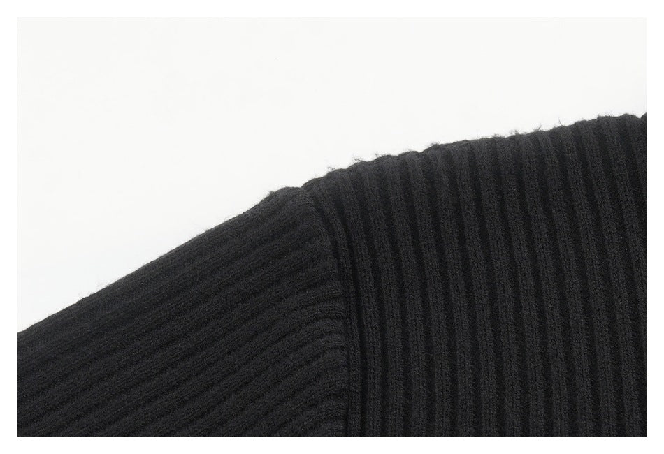 Close-up of a seam joining sections of black ribbed garment fabric.