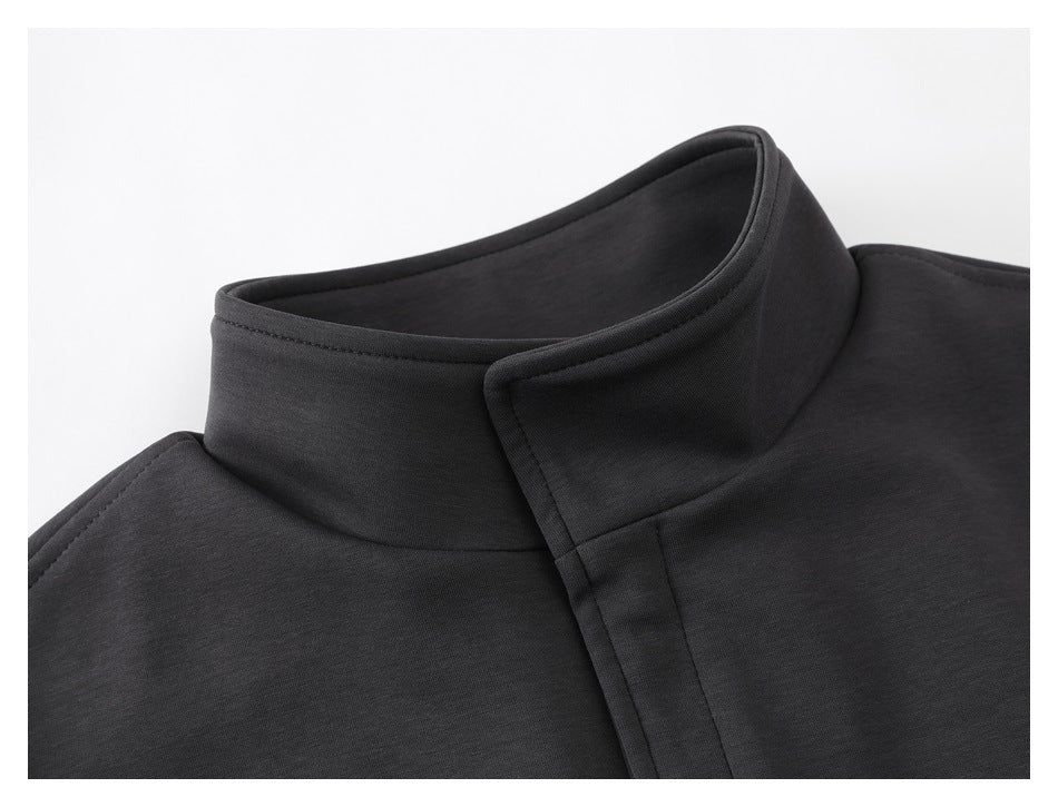 Close-up of a charcoal jacket's raised stand collar and overlapping front placket.