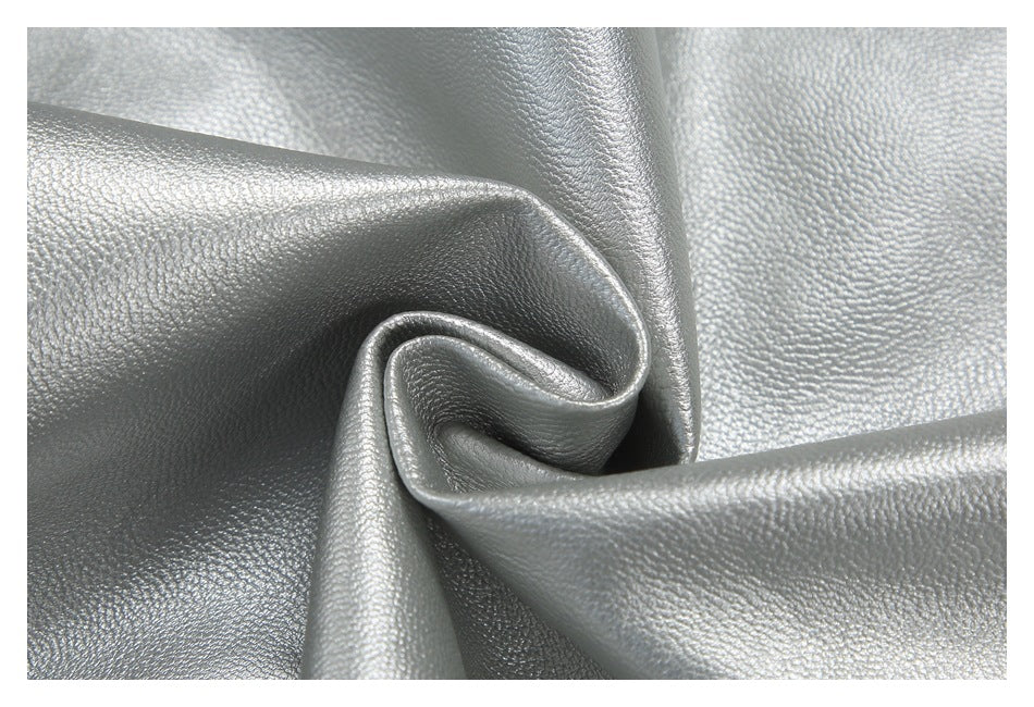 Close-up of shiny silver material gathered into a swirl, showing its pebbled surface.