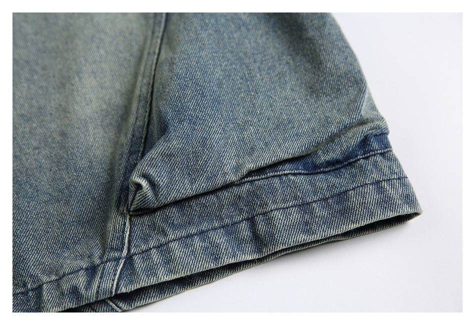 Close-up of the blue-gray washed denim garment's stitched hem and folded edge.