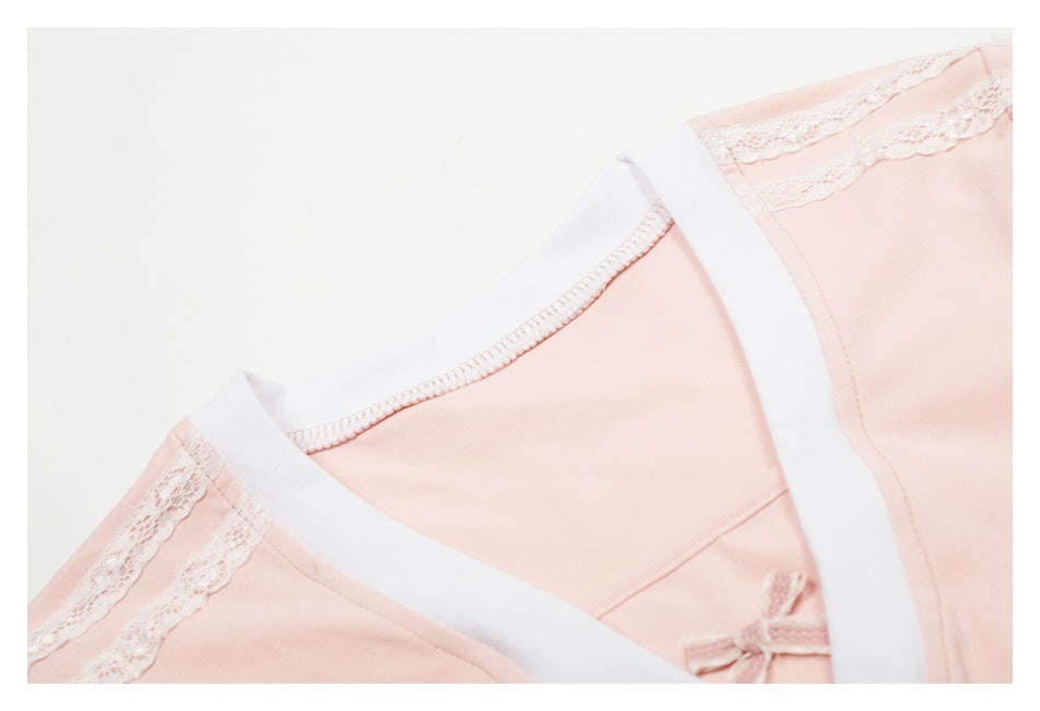 Close-up of the pale pink top's white-trimmed neckline and lace-trimmed shoulder seam.