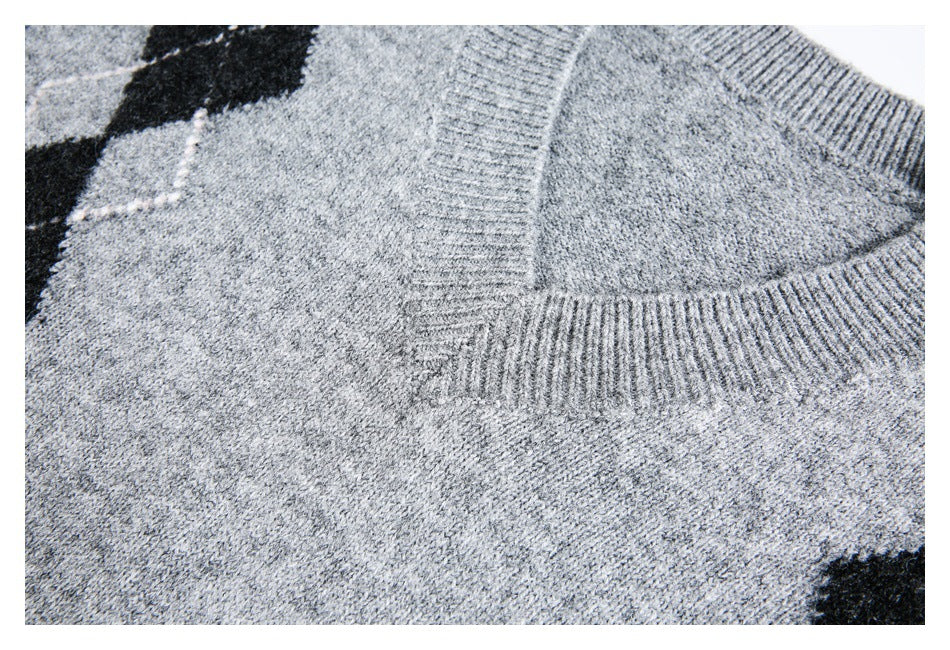 Close-up showing the ribbed V-neck trim and gray marled knit of an argyle sweater.