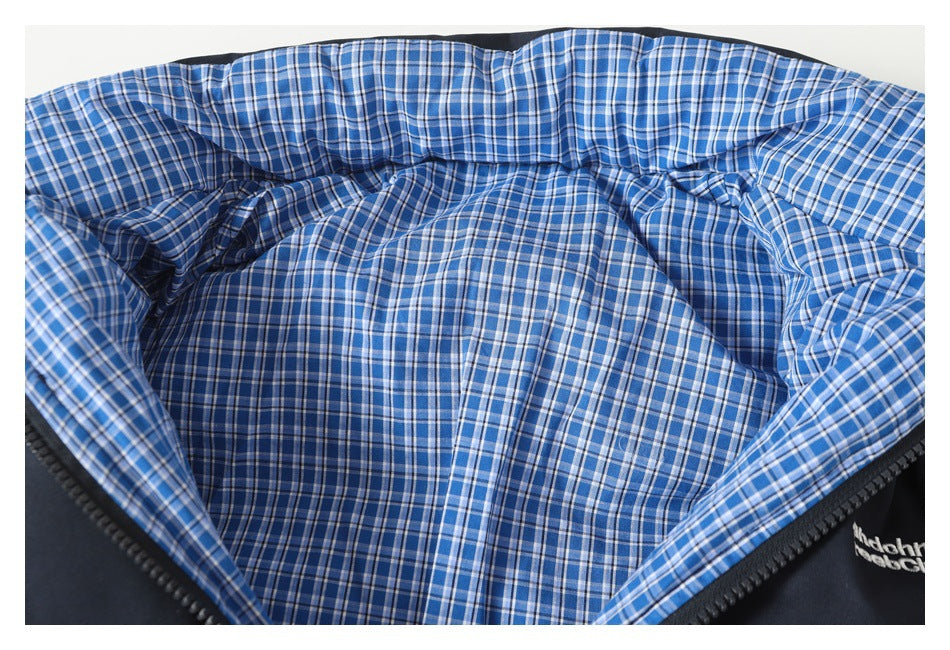 Close-up of the jacket's blue plaid lining spread open beside the dark zipper and outer shell.