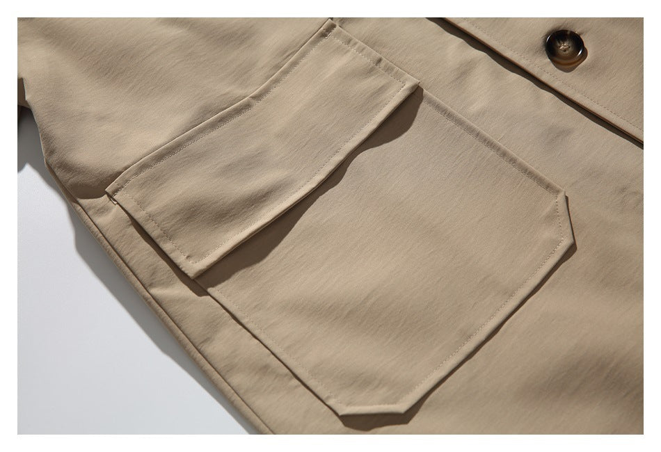 Close-up of a large patch pocket and smaller flap pocket on the beige coat.