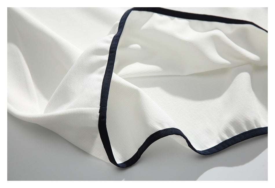 The white ribbed shirt is turned and draped to show its black-trimmed edge and fabric underside.