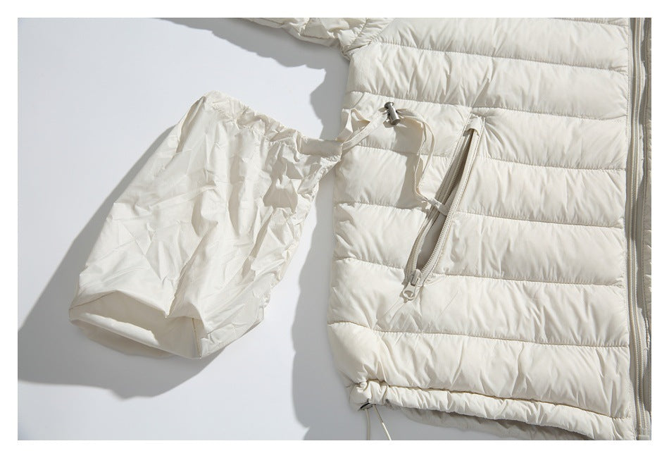 Cropped flat lay of an ivory quilted jacket with a matching gathered pouch and front zipper.
