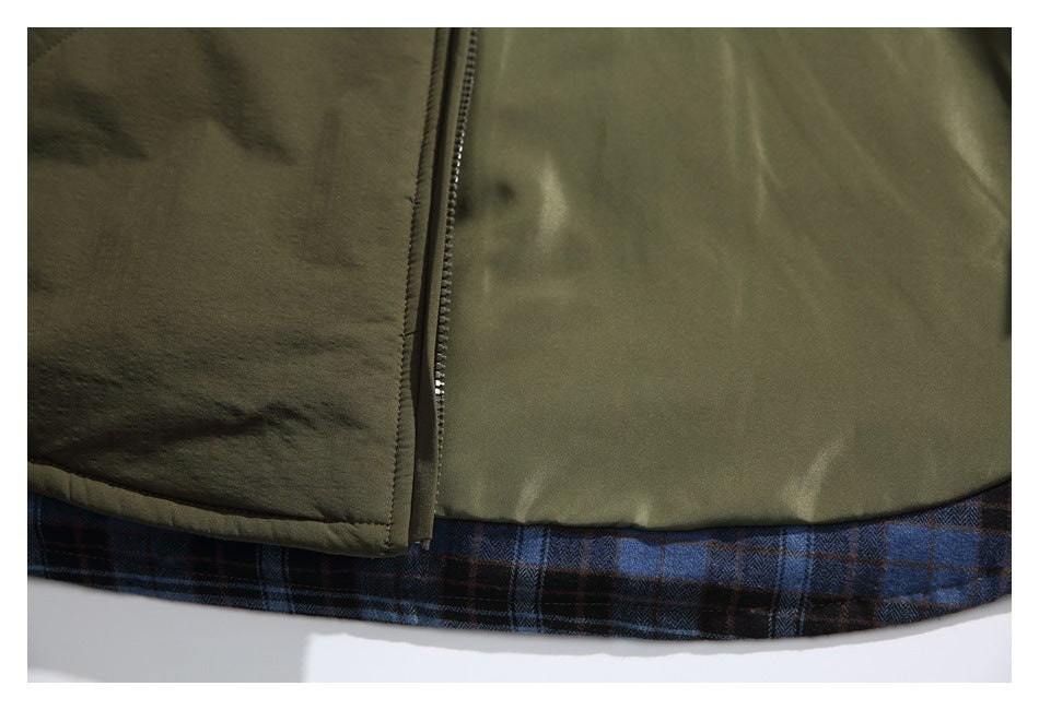 Close-up of the olive jacket's lower front zipper and hem, with blue and brown plaid lining exposed.