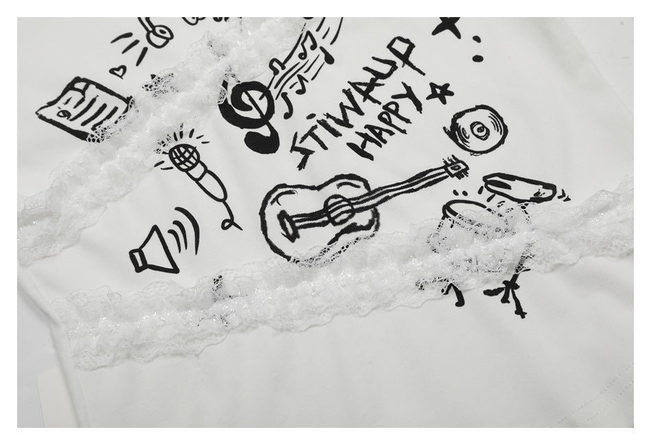 Close-up of a white garment with black music-themed doodles and lettering, crossed by sheer white lace trim.