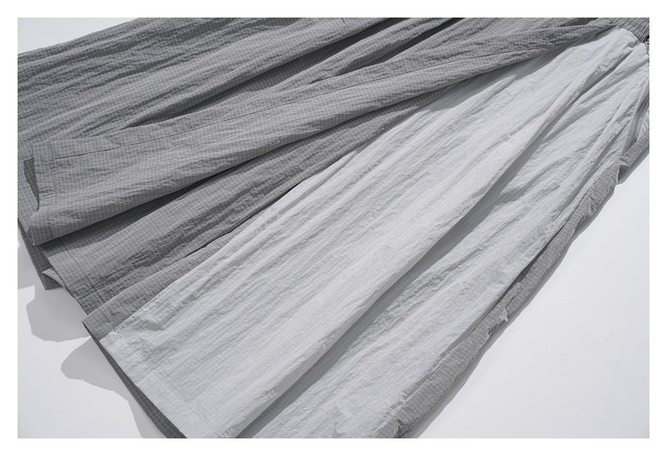 Gray grid-pattern trousers spread out to show their loose, wide legs.