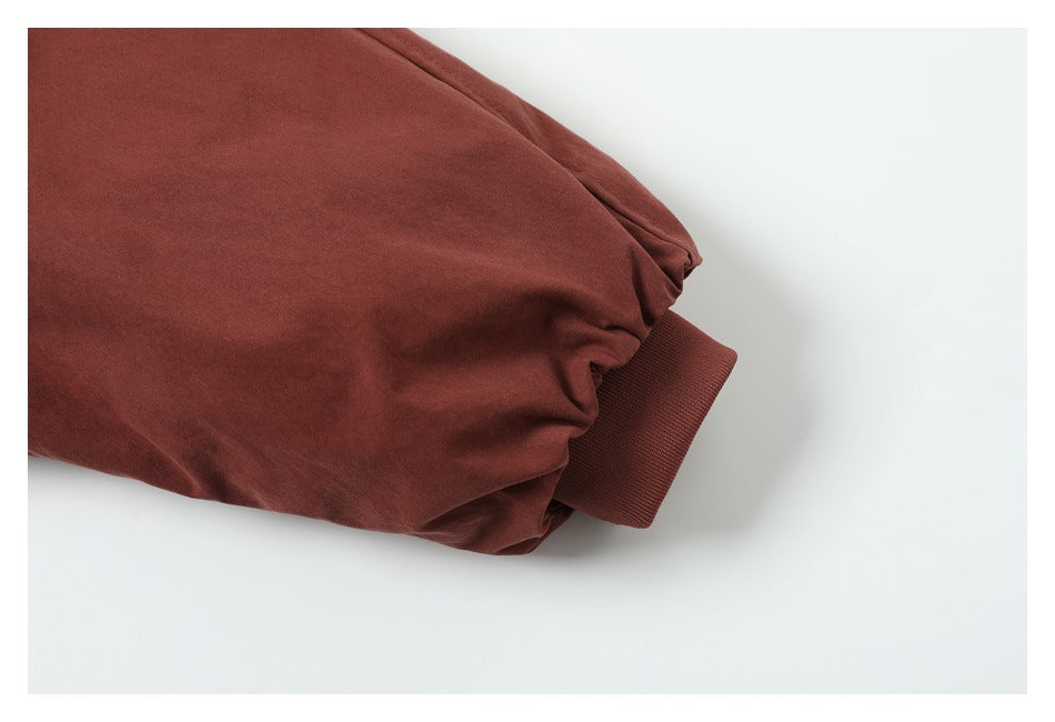 Close-up of a rust-red sleeve ending in a ribbed cuff.