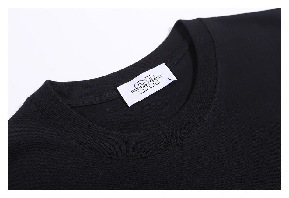 Close-up of a black T-shirt's crew neck, stitching, and inner label.