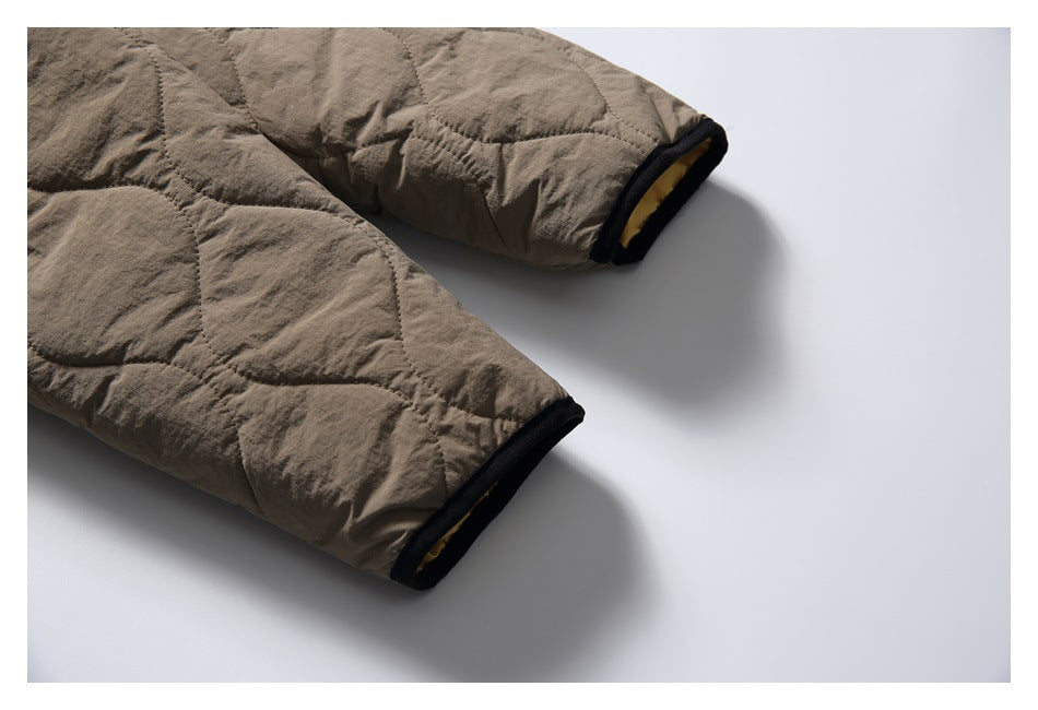 Close-up of the taupe jacket’s quilted sleeves and black-trimmed cuffs.
