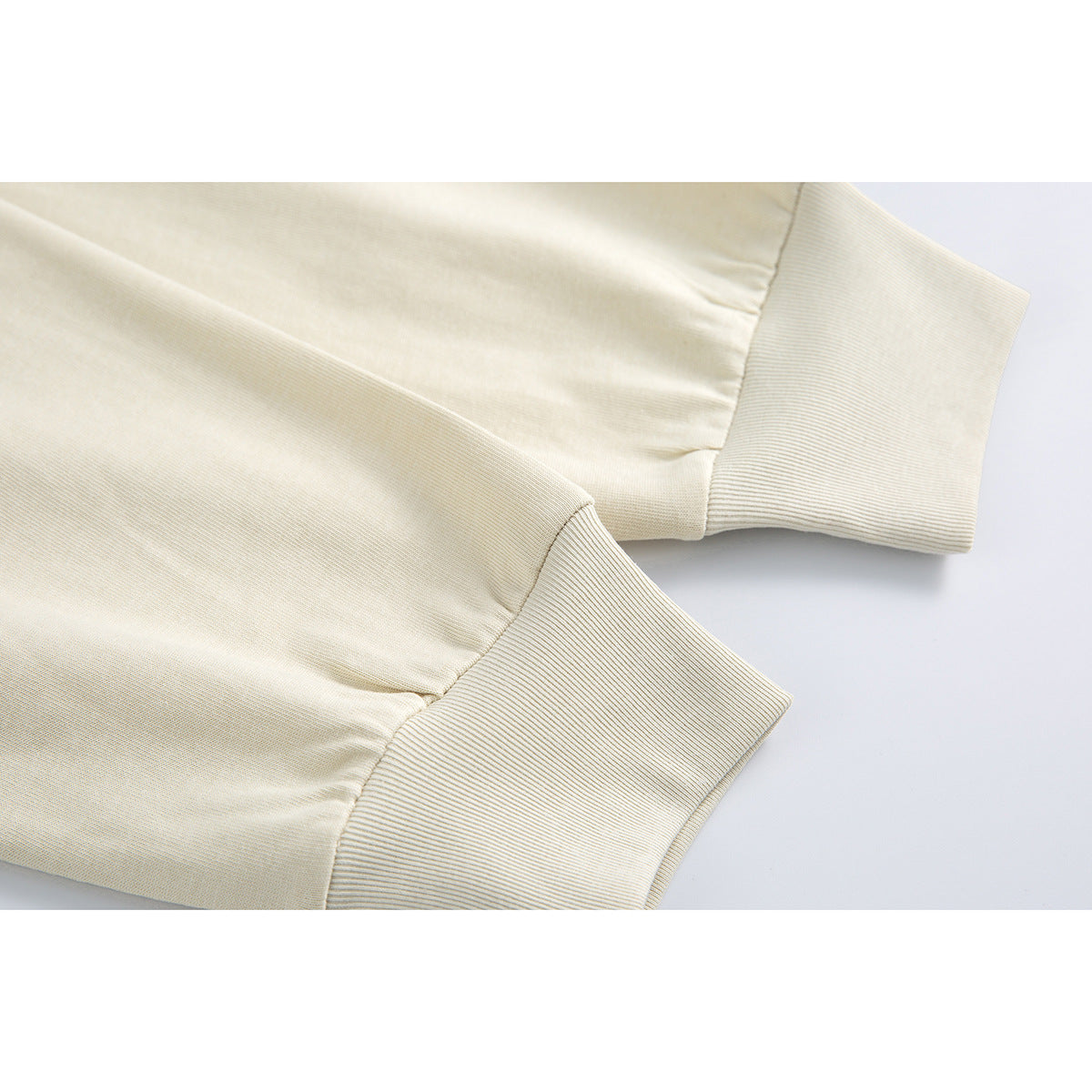 Close-up of a cream shirt's long sleeves and wide ribbed cuffs.
