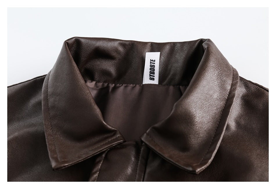 Close-up of a dark brown garment's wide collar and inner neck label.