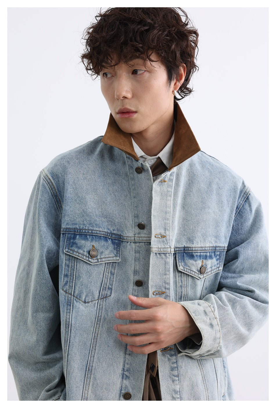Close front view of a model wearing a light-wash denim jacket with a brown collar and chest pockets.
