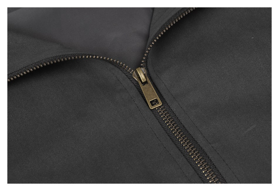 Close-up of the charcoal jacket's metal zipper and surrounding fabric.