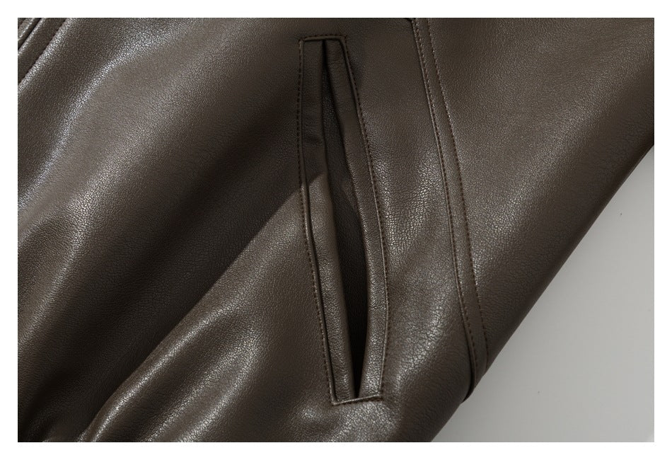 Close-up of a dark brown garment showing a narrow welt pocket and stitched seams.