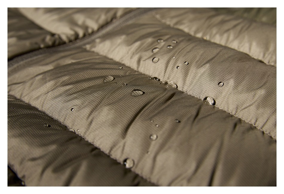 Close-up of taupe quilted fabric with water droplets beading on its surface.