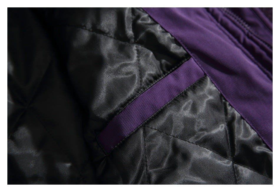 Close-up of black quilted jacket lining with a narrow purple fabric loop and purple edging.